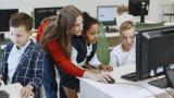 Teacher helping students with computers